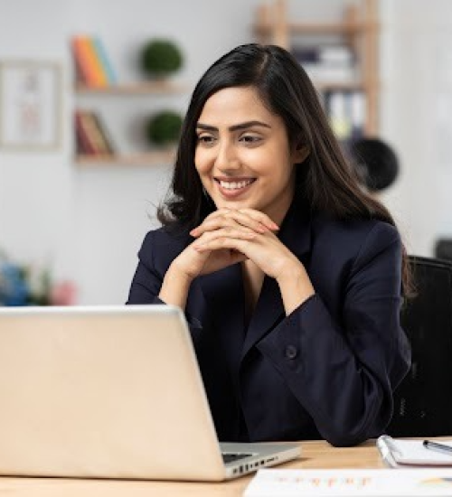 women smiling while looking at the laptop screen